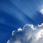 dark blue sky, clouds and solar beams